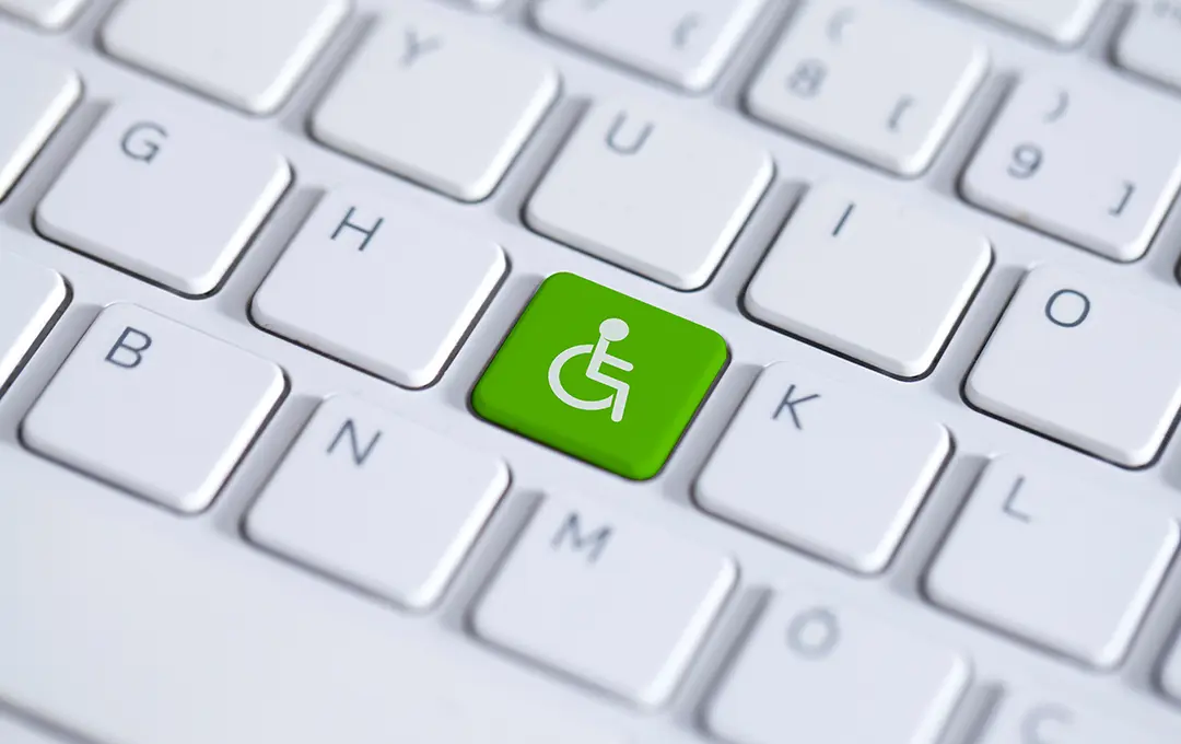 Tastatur mit grüner Taste und weißem Rollstuhlsymbol als Zeichen für Barrierefreiheit.